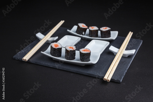 Set of traditional japanese food on a dark background. Sushi rolls. Asian food frame. Dinner party. 