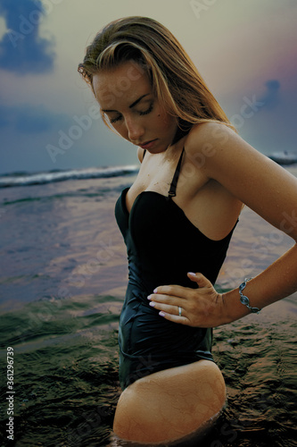 Girl posing in swimwear on the beach in water
