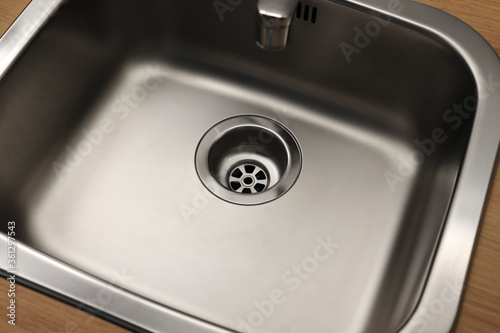 Close-up of a drain in a steel sink. Clean sink, no blockages. Water supply.