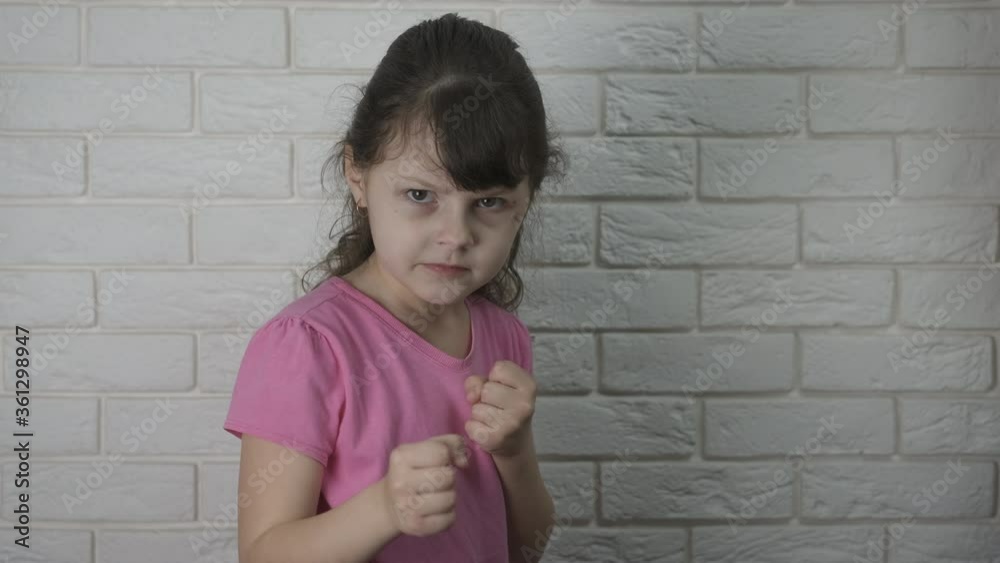 Child likes to fight. An angry little girl with wounds on her face strikes and takes a defensive posture. Child likes to fight. An angry little girl with wounds on her face strikes and takes a defensive posture.