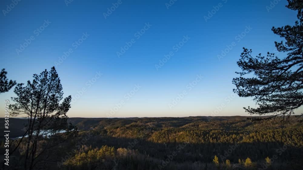 Sunlight illuminates forest in morning time lapse view from hilltop Sunlight illuminates forest in morning time lapse view from hilltop