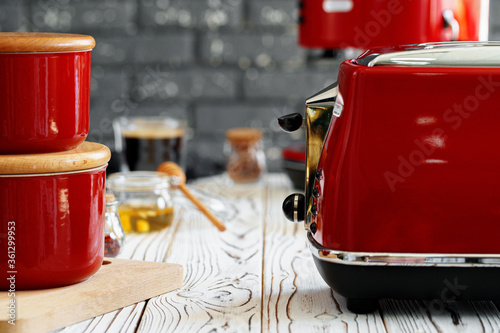 Close up photo of a red toaster on a kitchen table photo