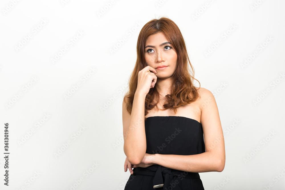Portrait of young beautiful Asian woman thinking and looking up Portrait of young beautiful Asian woman thinking and looking up