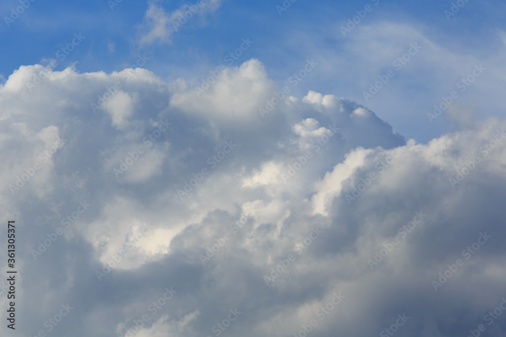 White clouds against the blue sky background in sunny cloudy summer day.