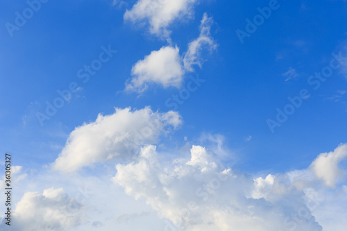 White clouds against the blue sky background in sunny cloudy summer day.