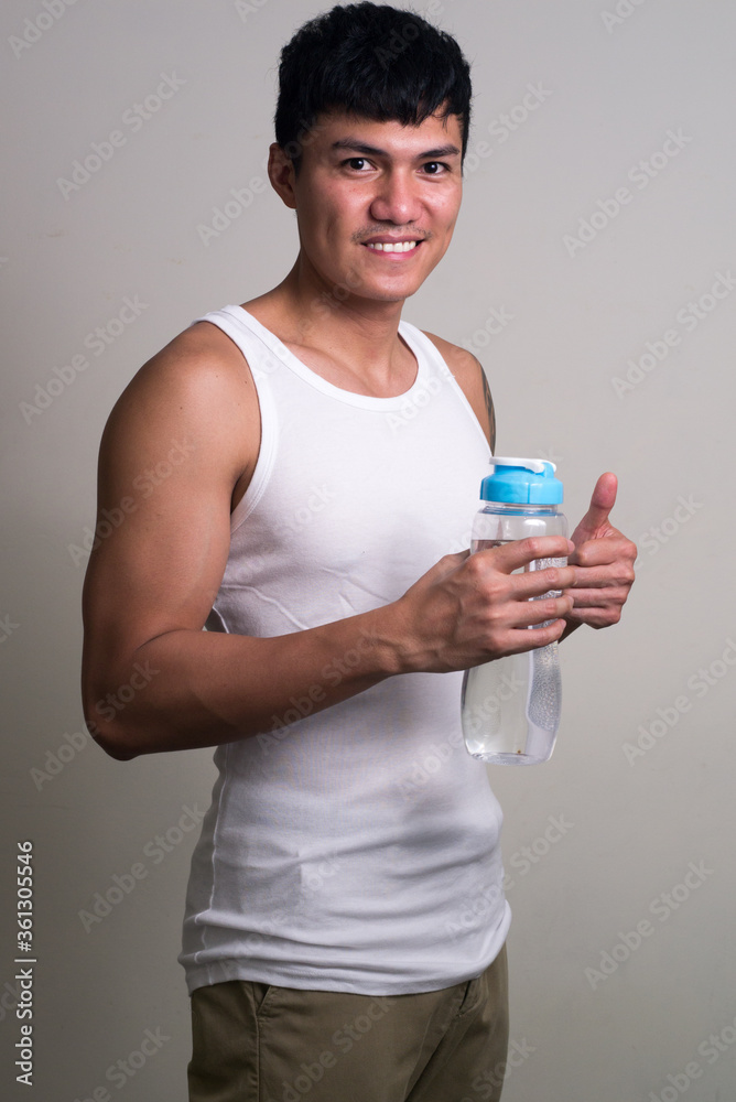 Portrait of happy young handsome Asian man smiling and ready for gym Portrait of happy young handsome Asian man smiling and ready for gym