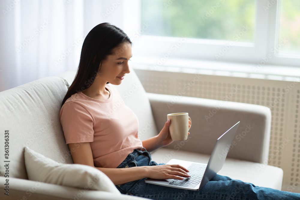 Woman Using Laptop Relaxing With Cup Of Coffee At Home Woman Using Laptop Relaxing With Cup Of Coffee At Home