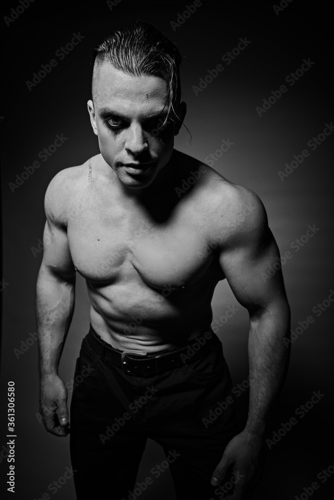 A man with raised muscles and a naked torso A man with raised muscles and a naked torso