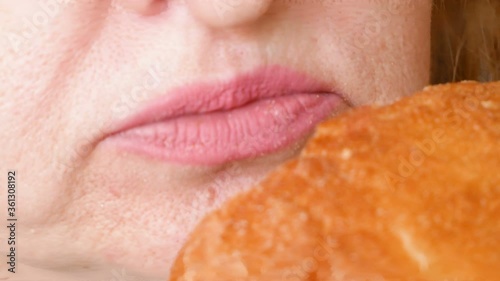 hungry woman eating big bun closeup, unheathy food concept photo