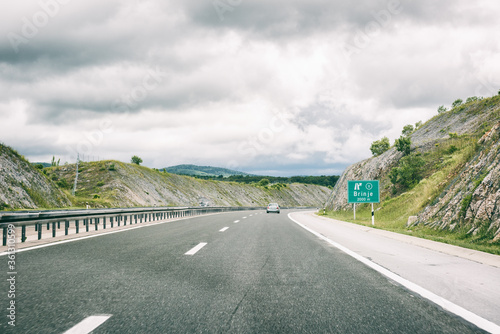 Picturesque highway in Croatia  autocesta A   the main automobile road with pointer. Scenic daytime landscape with fantastic clouds  shoot in motion