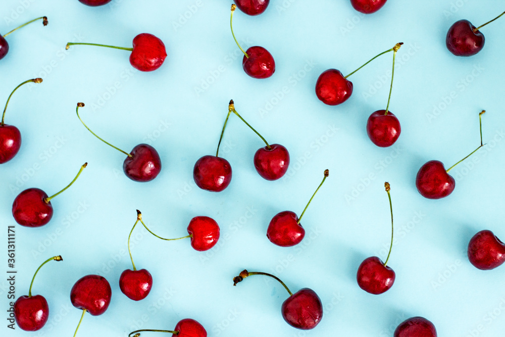 Cherry berries on a blue background top view, flat lay, pattern. Berry background for creativity. Cherry berries on a blue background top view, flat lay, pattern. Berry background for creativity.