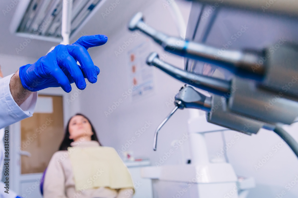 Dentist's hands with blue gloves work with a dental tools. close Dentist's hands with blue gloves work with a dental tools. close