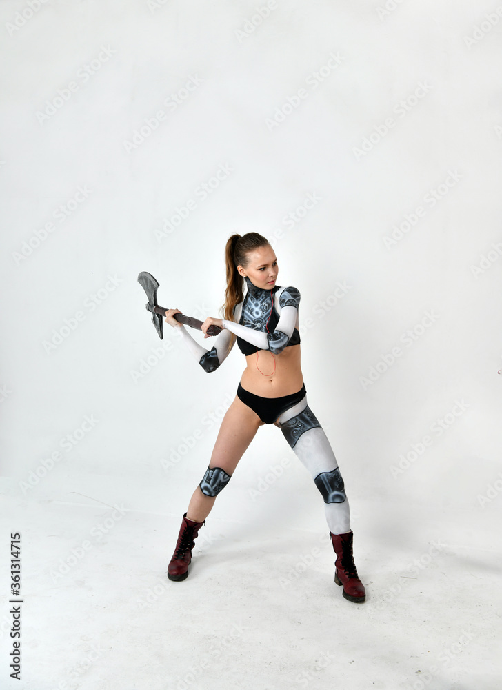 beautiful girl in a robot suit with a battle ax does exercises on a white background beautiful girl in a robot suit with a battle ax does exercises on a white background