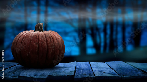 Tela One spooky halloween pumpkin blank template on a wooden bench with a misty forest night background with space for product placement