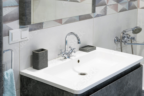 Foto Modern bathroom interior with metal faucet and ceramic white sink