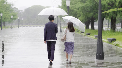雨の日に傘を差してデートするカップル