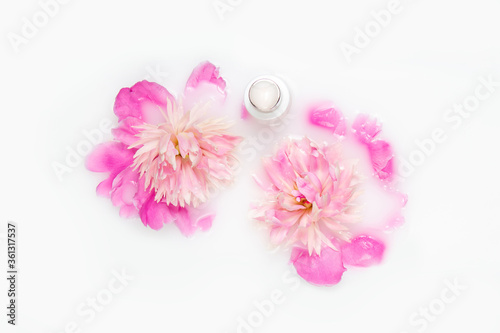 Natural cosmetics. Cream and peony flower in a bath with milk. Conceptual photo: the best cosmetic tool for body and face care. Gentle care.