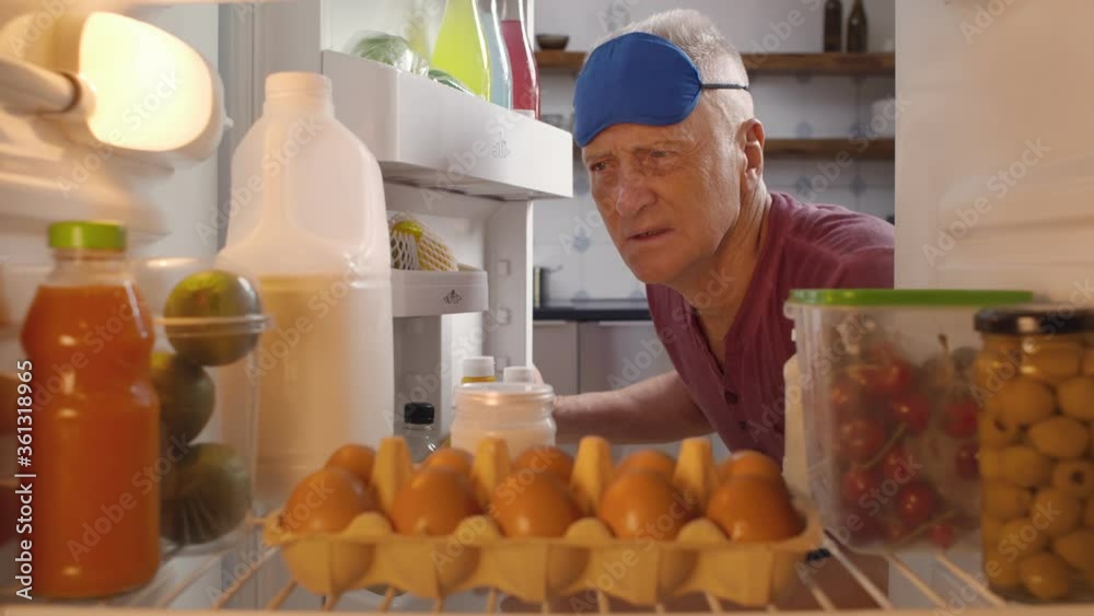 Mature man taking bottle of milk from fridge for breakfast Mature man taking bottle of milk from fridge for breakfast