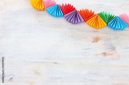 Paper colorful chain garland over white wooden background. Traditional jewish sukkot holiday decoration © tomertu