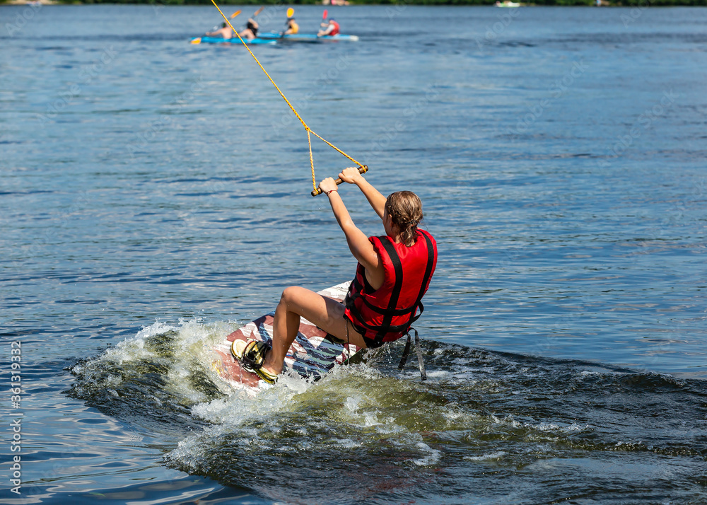 Fototapeta premium Wakeboard. Woman surfing on the river on a board