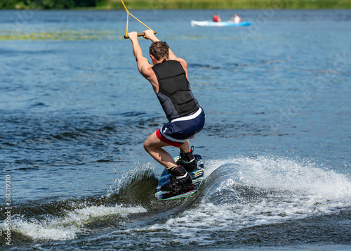 Wakeboard. Man surfing on the river on a board