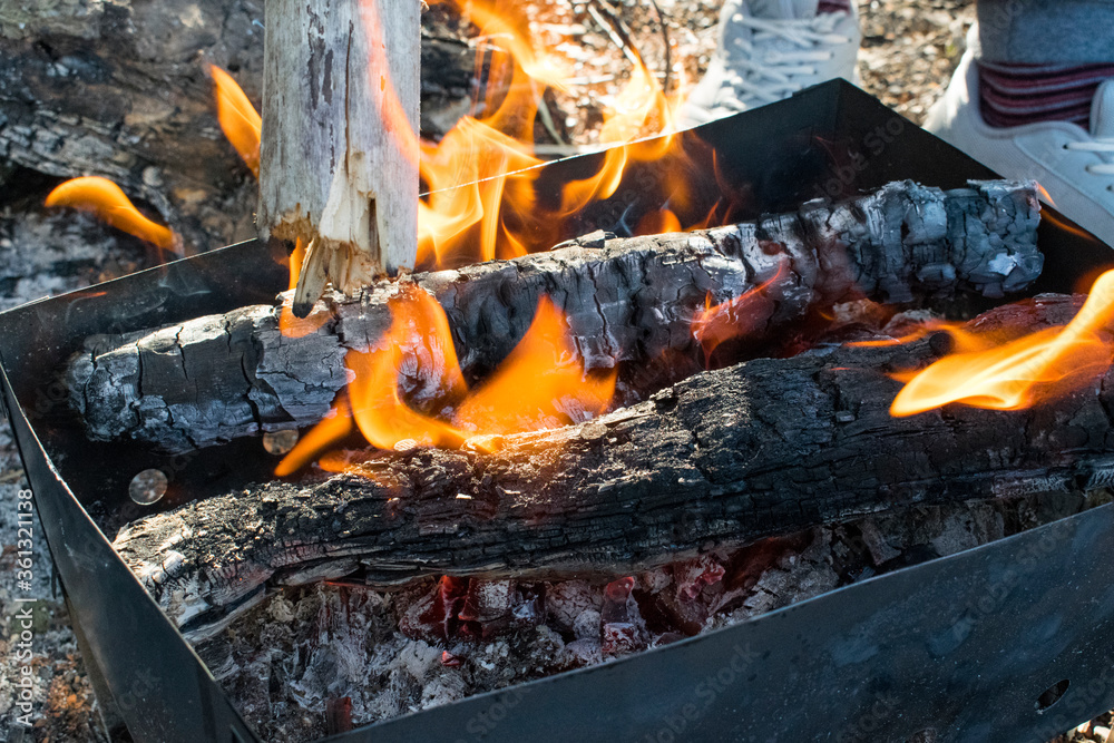 A fire is burning, a barbecue, charred logs A fire is burning, a barbecue, charred logs
