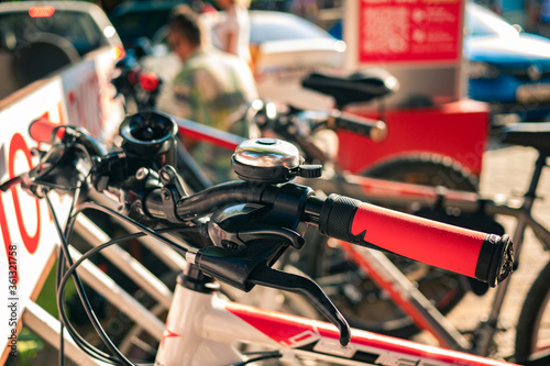 Close-up of a bicycle steering wheel lit by sunlight. Bicycle parking in sunny weather close-up.