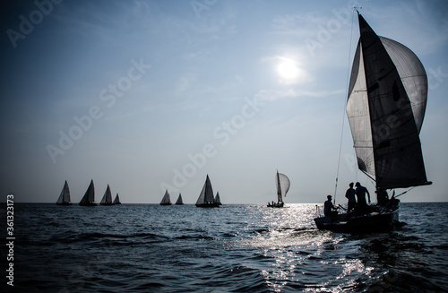 Sailing yacht race. Ship yachts with white sails in the open Sea. silhouettes of yachtsmen and boats