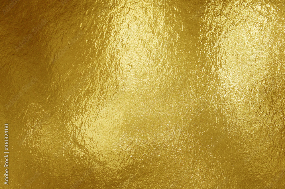 Gold foil texture background with highlights and uneven surface Gold foil texture background with highlights and uneven surface