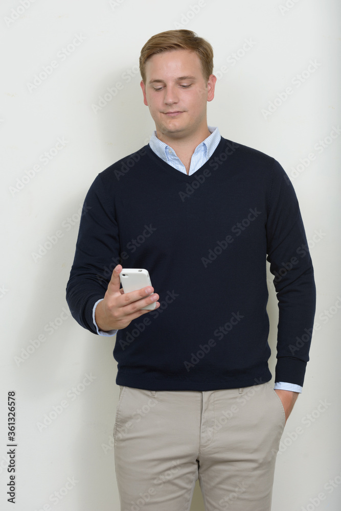Portrait of man with blond hair using phone