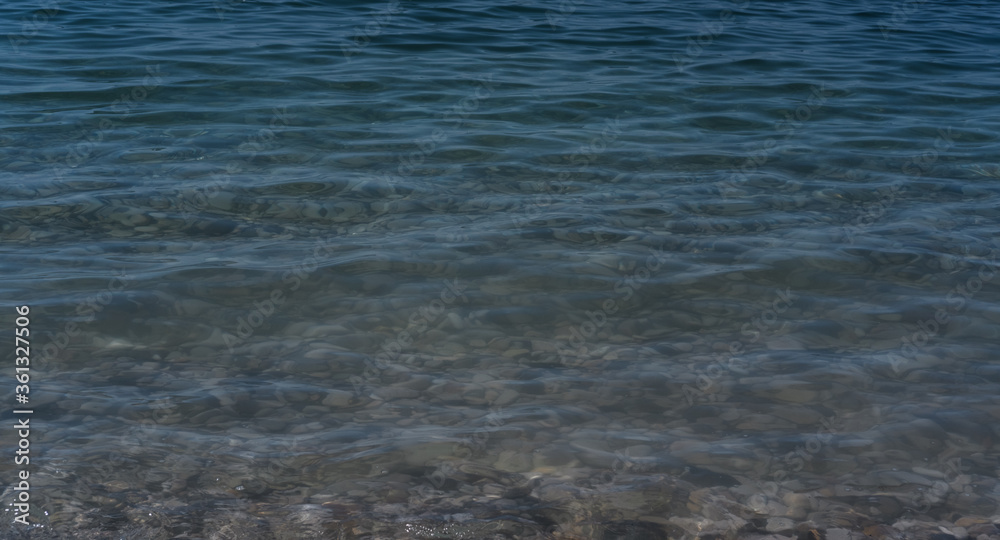 Clear sea water, and rocks on the bottom. Black sea with blue and emerald green water.