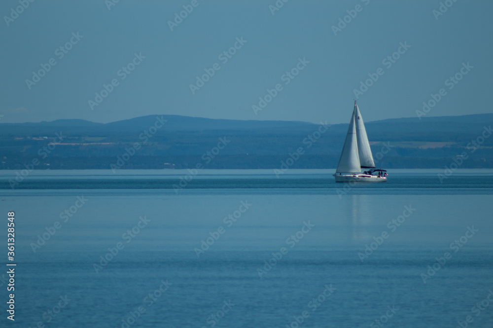 Sailboat On the Sea With Distant Mountains