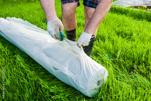 A man uses geotextiles in gardening. photo