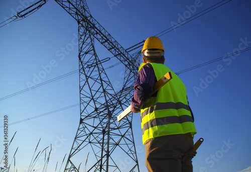 Engineer during power line inspection. Electrician at work. Production and supply of energy from power plants.