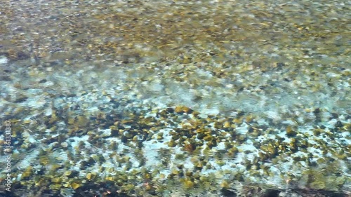 crystal clear water flow in river and visible underwater stone 