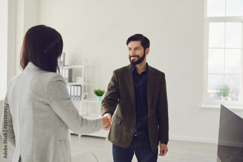 Smiling formal man and woman meeting in office
