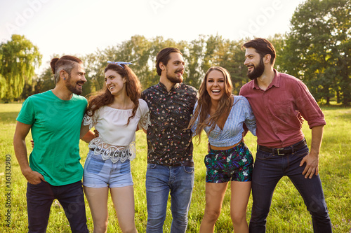 Portrait of happy friends posing in countryside during summer vacation. Young people having fun time together outdoors