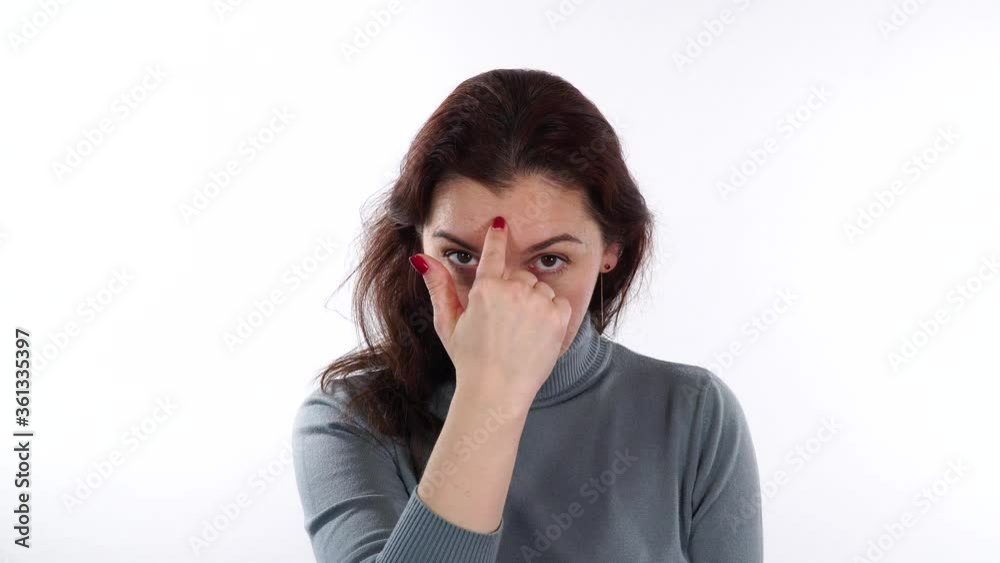 Brunette caucasian woman show sign - you are crazy. Model's finger at her forehead and it's means that someone is crazy. Brunette caucasian woman show sign - you are crazy. Model's finger at her forehead and it's means that someone is crazy.