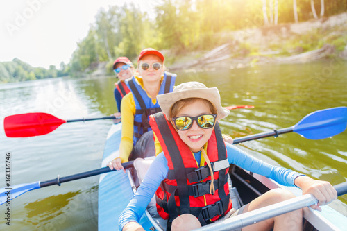 Happy boy kayaking on the river on a sunny day during summer vacation