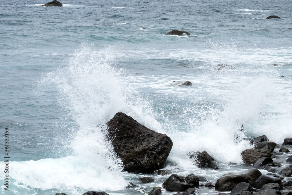 An ocean tide on the pebble beach of Madeira island An ocean tide on the pebble beach of Madeira island