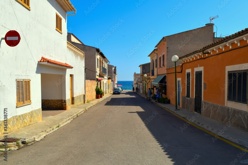 Light street, leading to the coast of the sea with blue bright sky