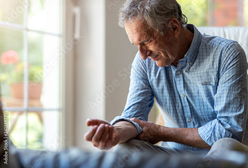 Senior man with arthritis rubbing hands
 photo