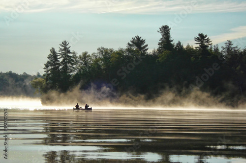 Foto Canoeing at sunrise on a misty lake
