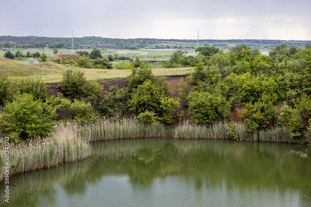 Old flooded rock quarry lake with clean transparent water