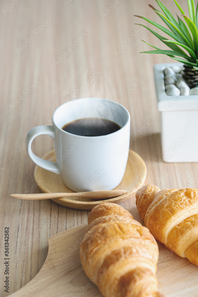 Two fresh croissants and cup of coffee on dark stone table Two fresh croissants and cup of coffee on dark stone table
