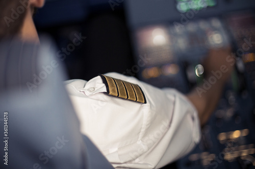 Young pilot in the aircraft in front of the dashboard. Pilot control airplane. Flight by commecial Airlines. Pre-flight preparation before the flight.Image with selestive focus. photo