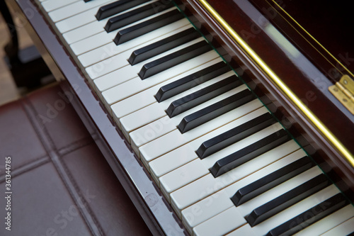 piano presses . Piano keys close up. Musical instrument . Select focus and soft focus.Close-up of a wooden piano . Defocused classic piano keyboard in white and brown colors .