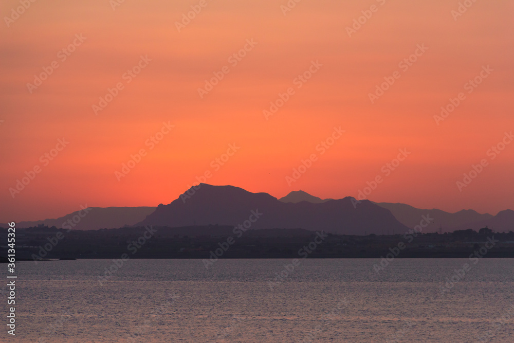 Image taken from a beach at Spain with the sun in the background. Cat cape concept.