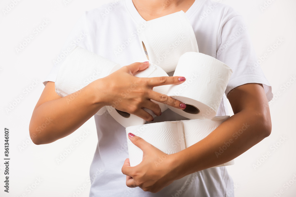 Closeup Asian young woman stocking up toilet paper for home panic in stores quarantine from coronavirus. Female holding many rolls of toilet paper in arms on chest, studio isolated on white background Closeup Asian young woman stocking up toilet paper for home panic in stores quarantine from coronavirus. Female holding many rolls of toilet paper in arms on chest, studio isolated on white background