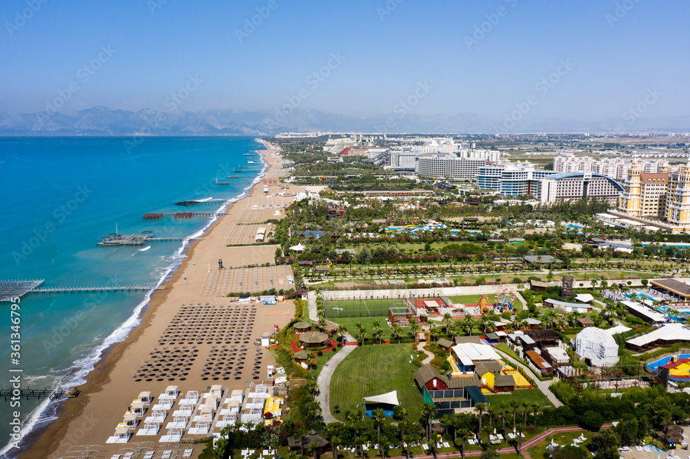 Fototapeta premium Sandy beaches of the Mediterranean. Kundu holiday complex with five star hotels. Beach, sea, water sports, parasailing, entertainment and shopping center. Aerial view with drone. Kundu, Lara -TURKEY